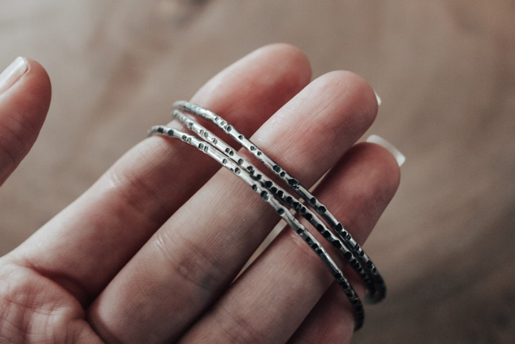 textured silver bangles with patina